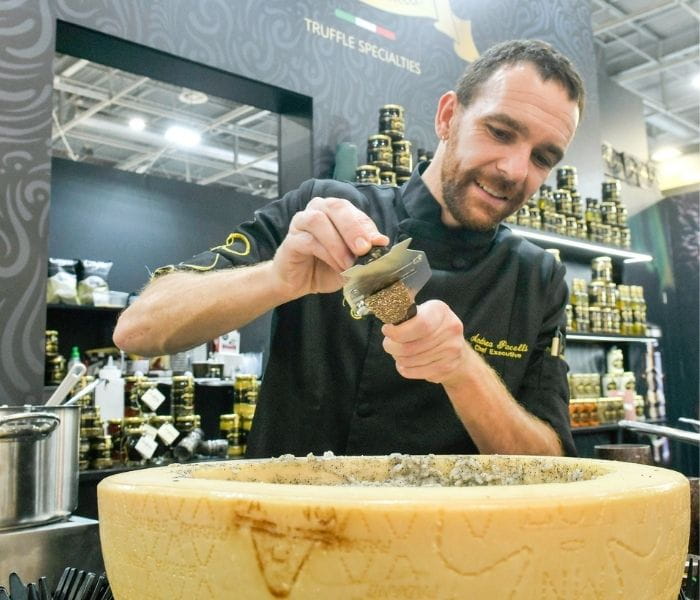 Exposant de SIAL Paris avec une meule de Parmesan